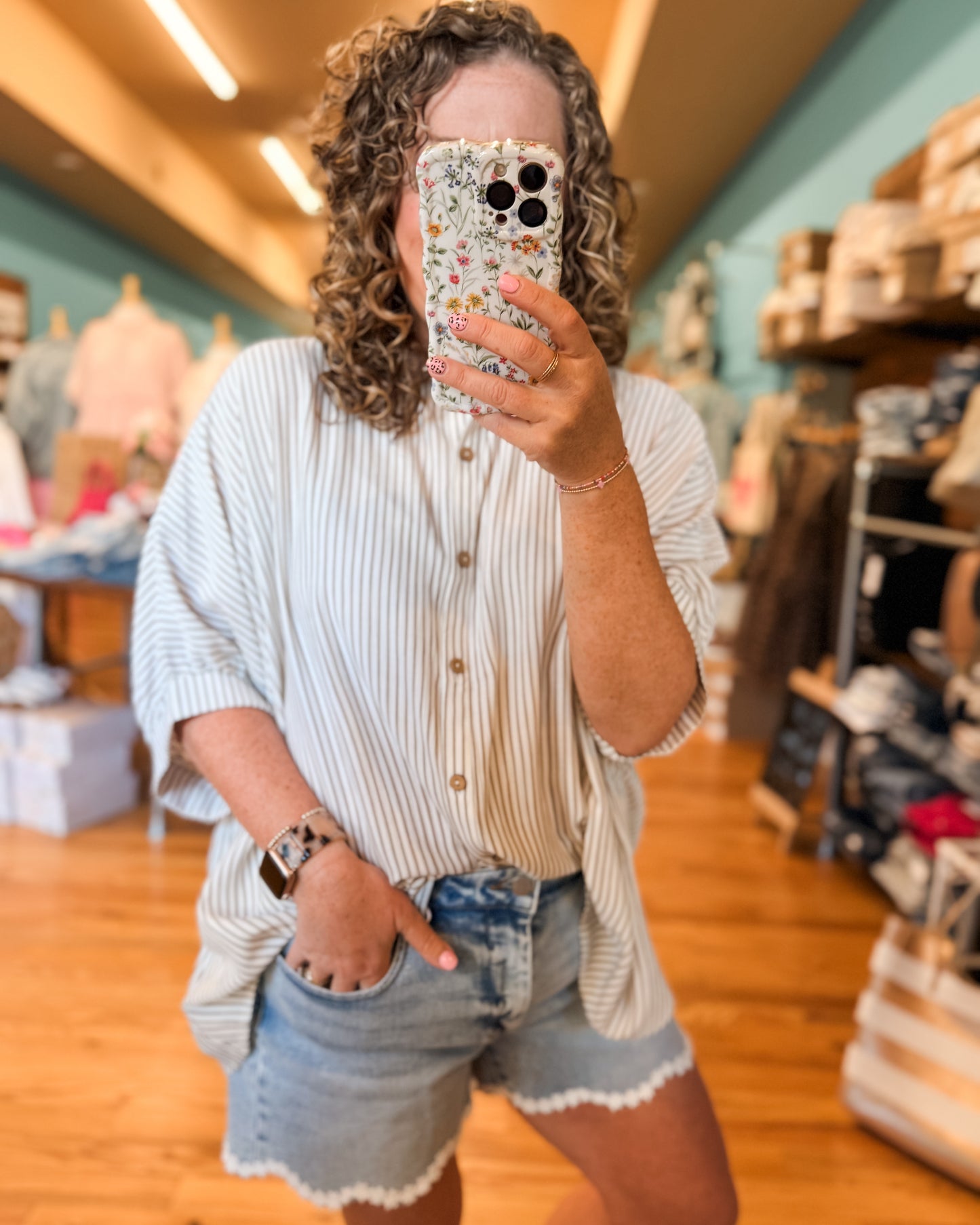 a striped button down top in mocha, oversize fit, pairs well with any denim. perfect for a front tuck style