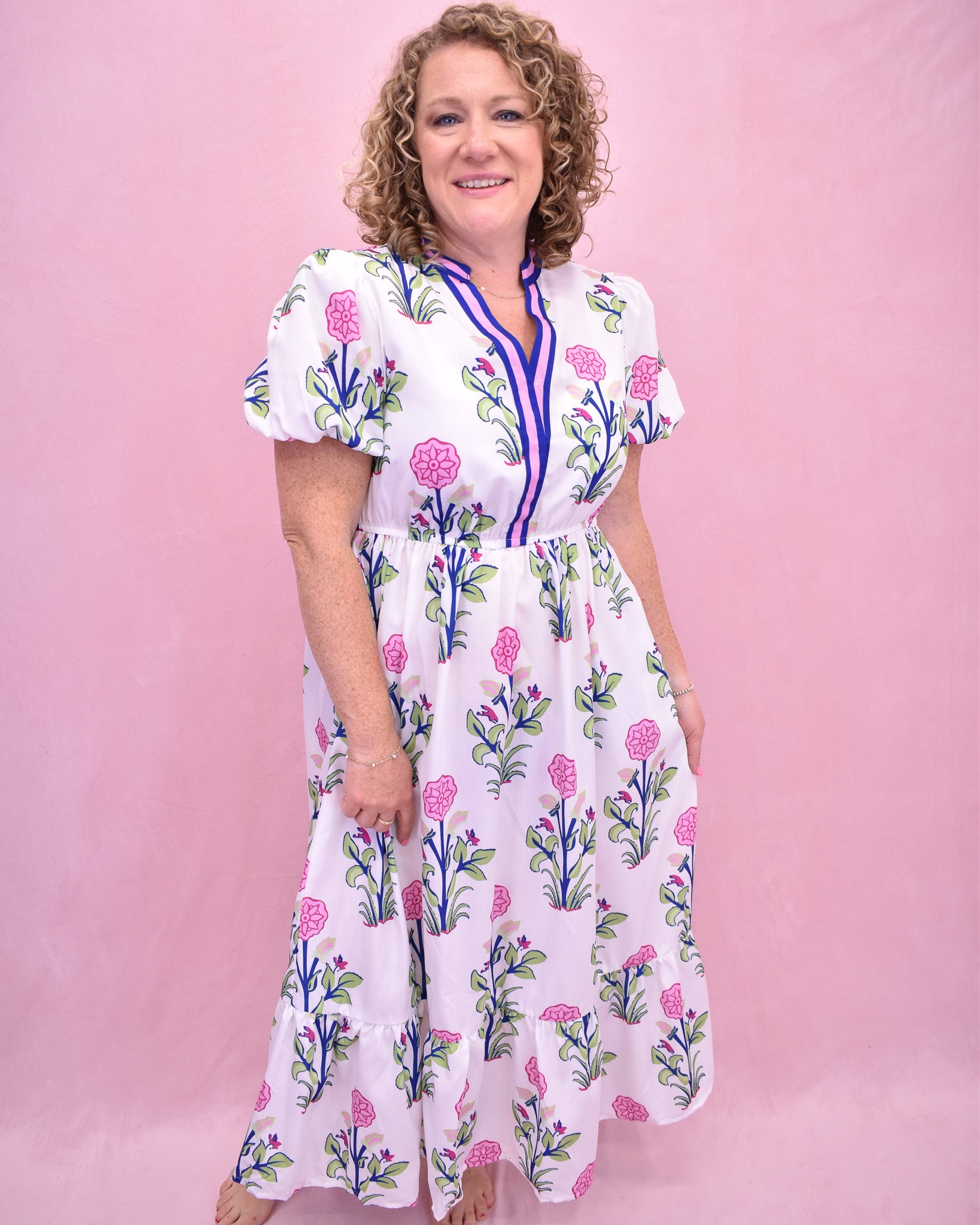 Woman wearing a floral dress against a pink background