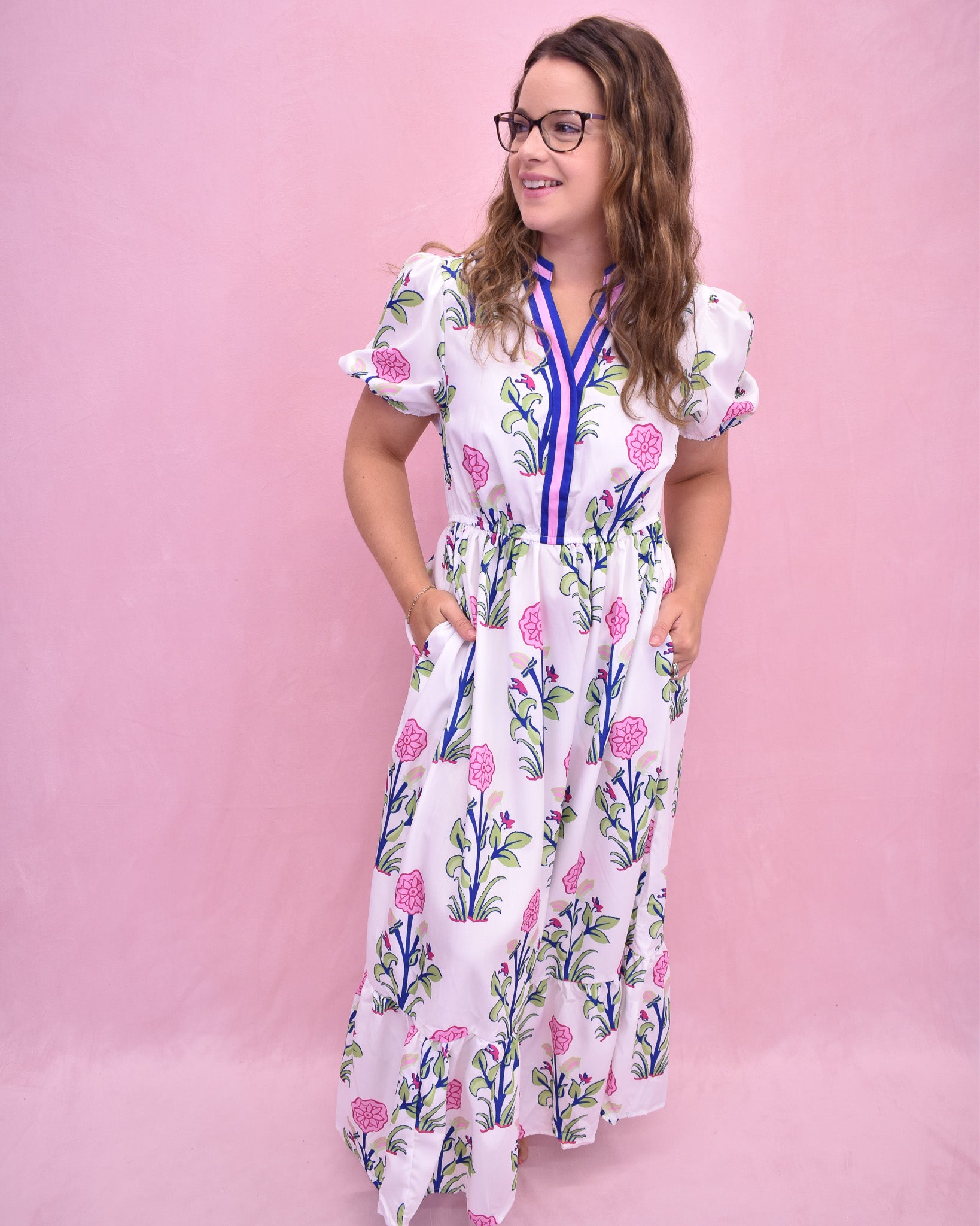 Woman wearing a floral dress against a pink background