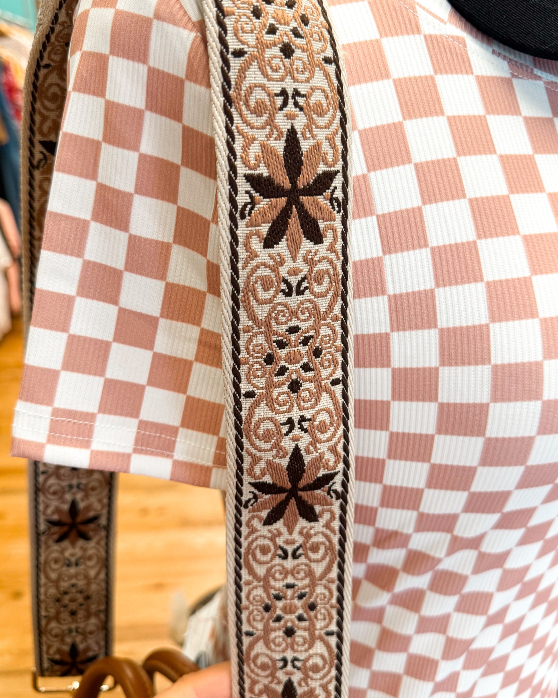 Close-up of a checkered fabric with decorative border on a wooden surface