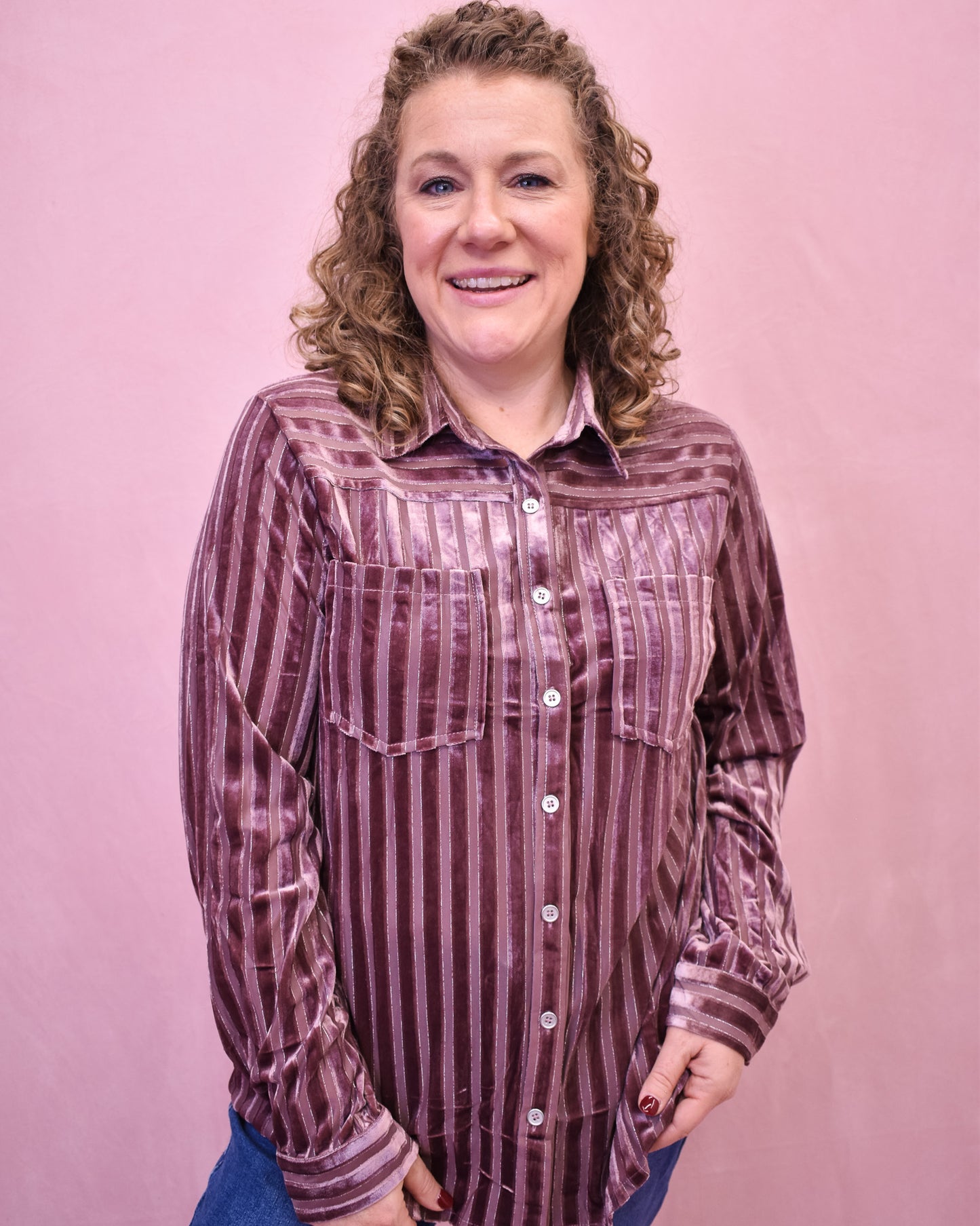 Woman wearing a striped shirt against a pink background