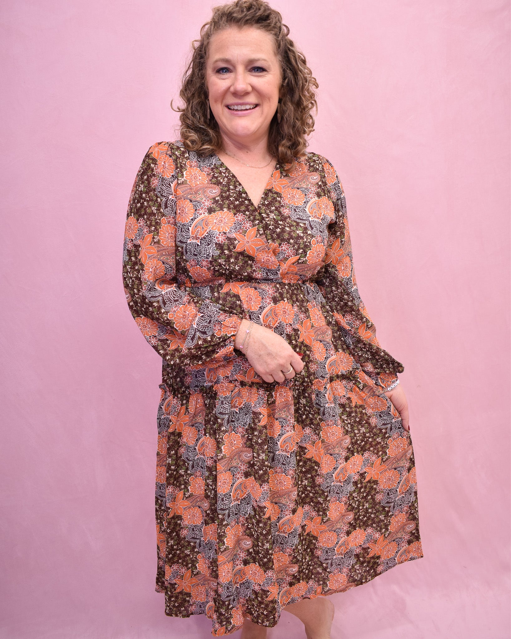 Woman wearing a floral dress against a pink background