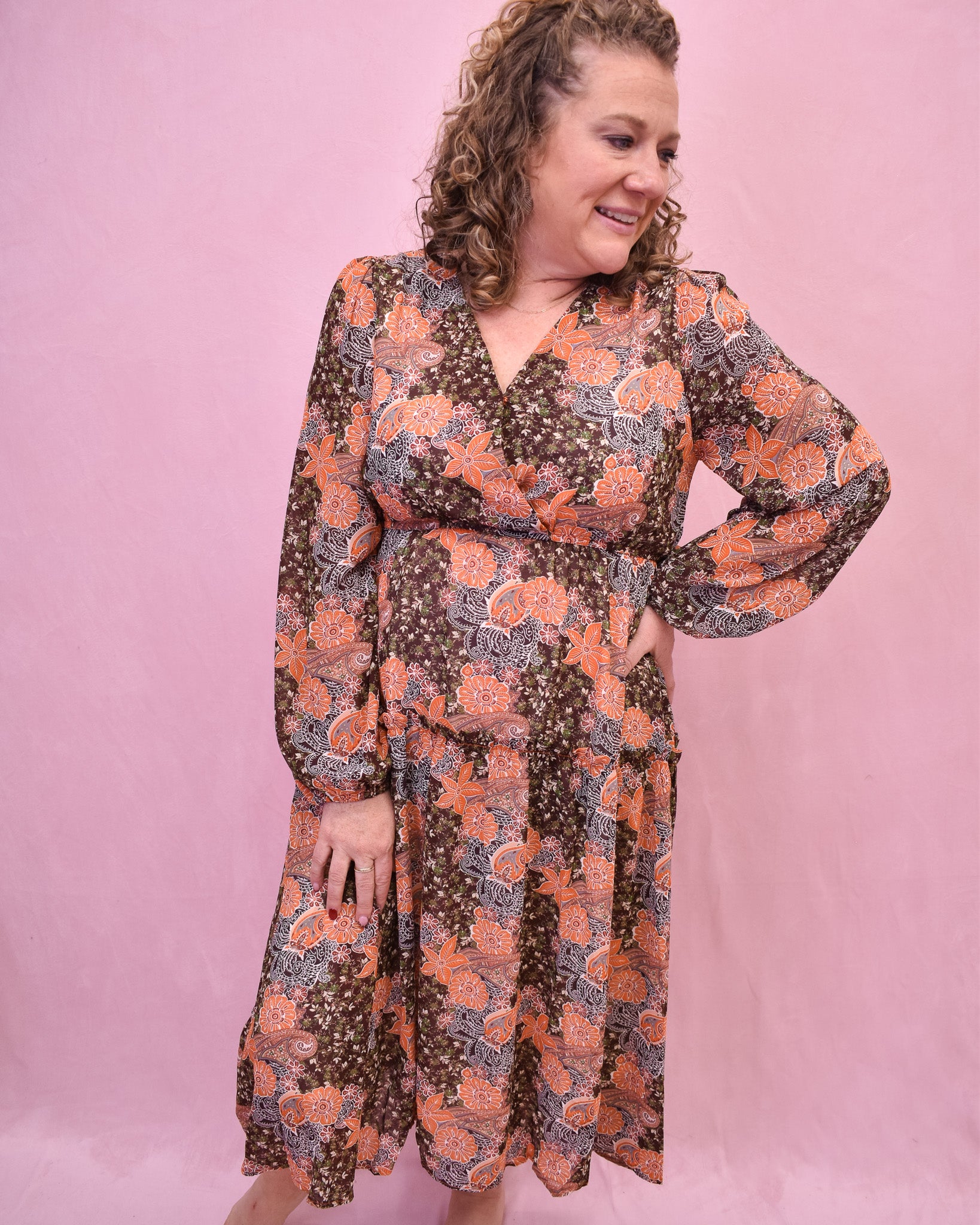 Woman wearing a floral dress against a pink background