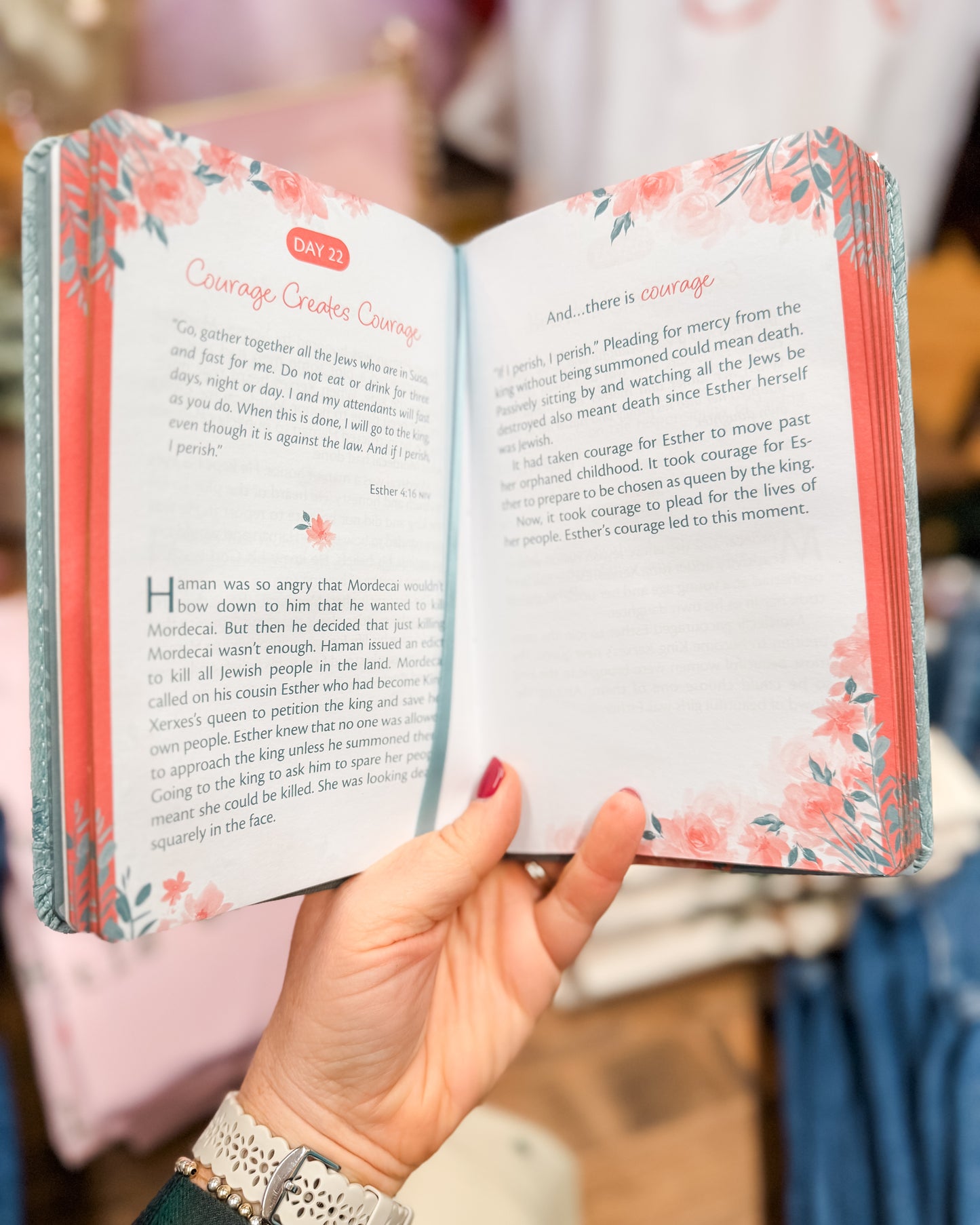Open book with floral design on the cover held by a person.