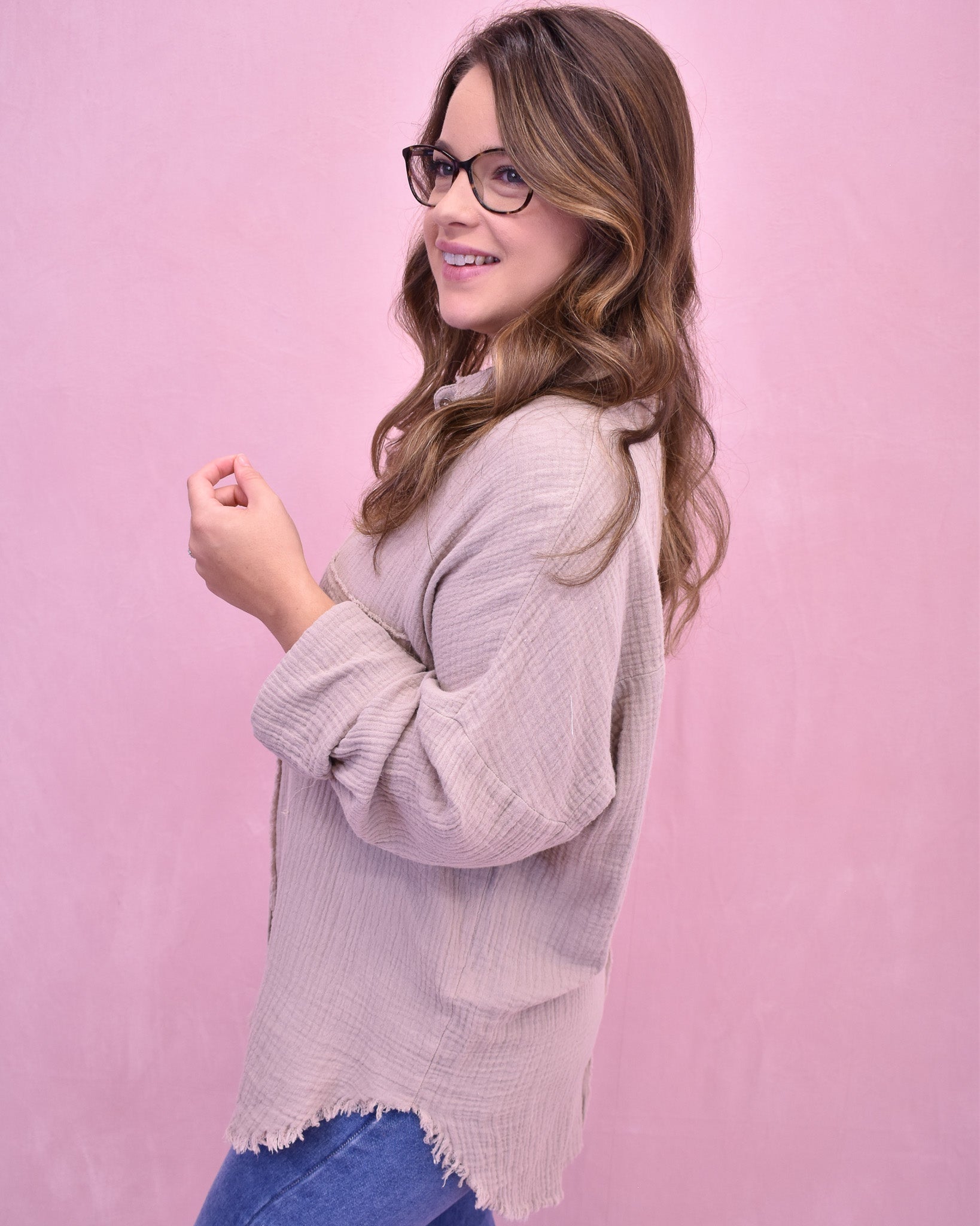 Woman wearing a light pink sweater against a pink background