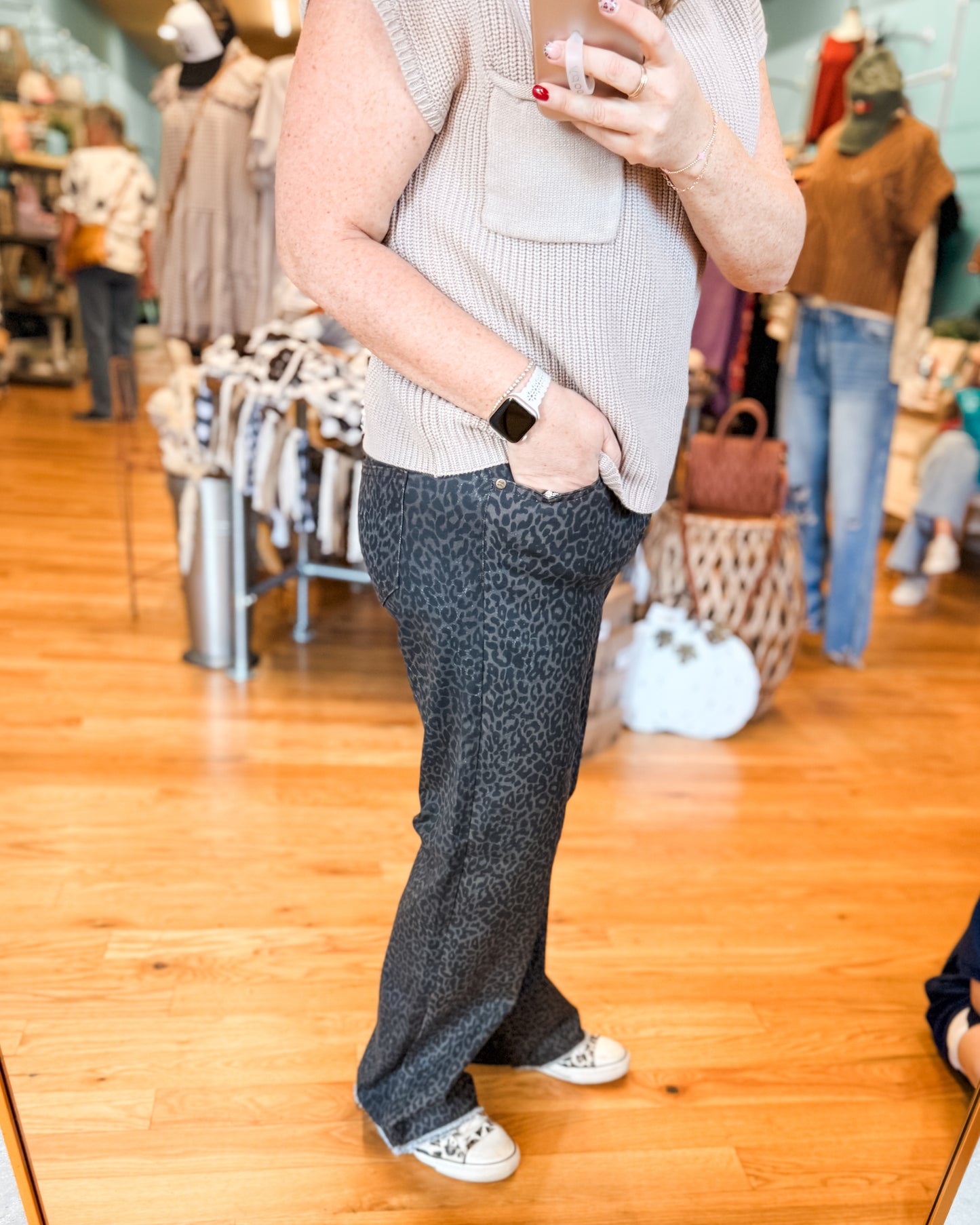 Person wearing a sleeveless top and patterned pants in a store setting