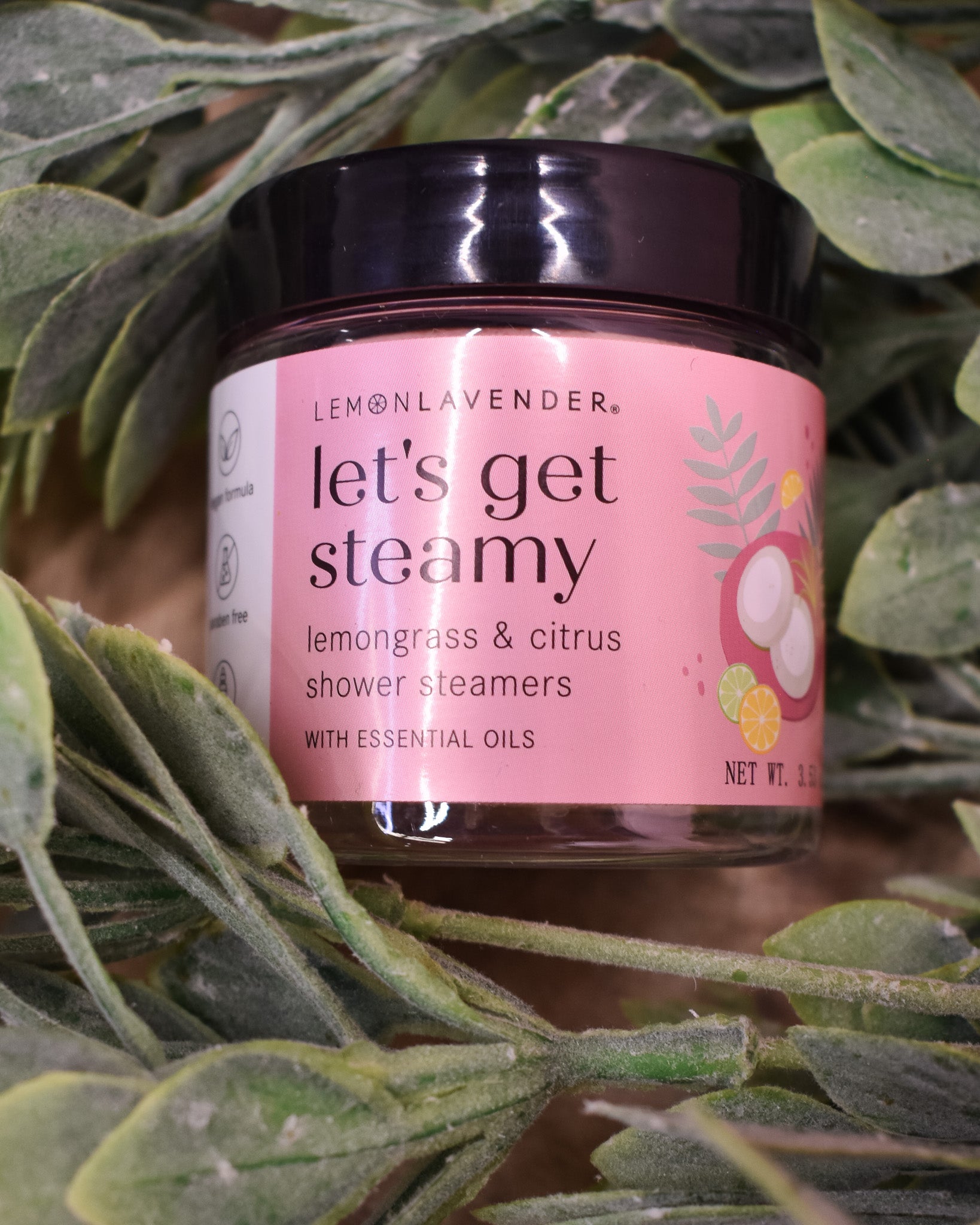 Jar of 'let's get steamy' shower steamers with a pink label on a green leafy background
