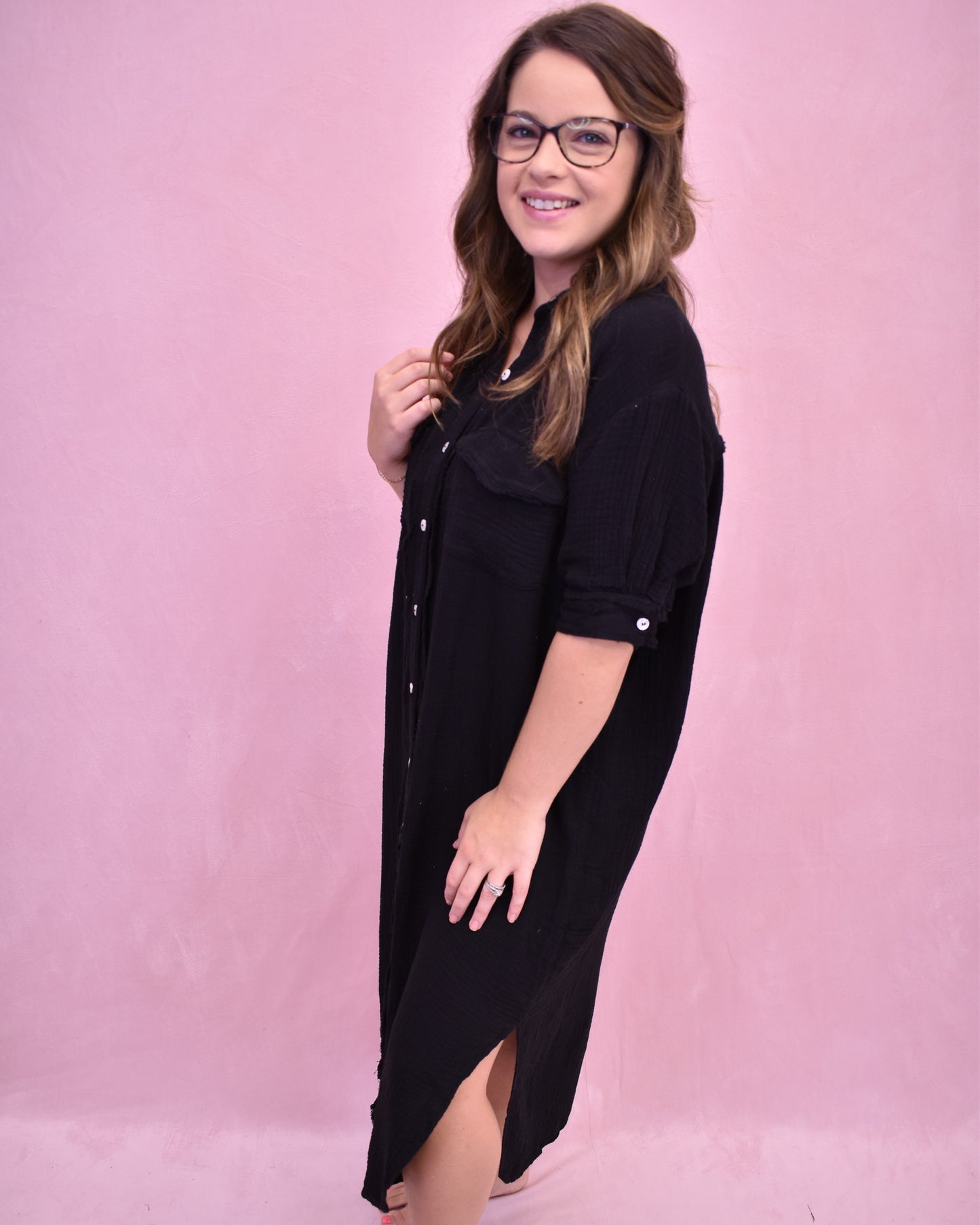 Woman wearing a black dress against a pink background