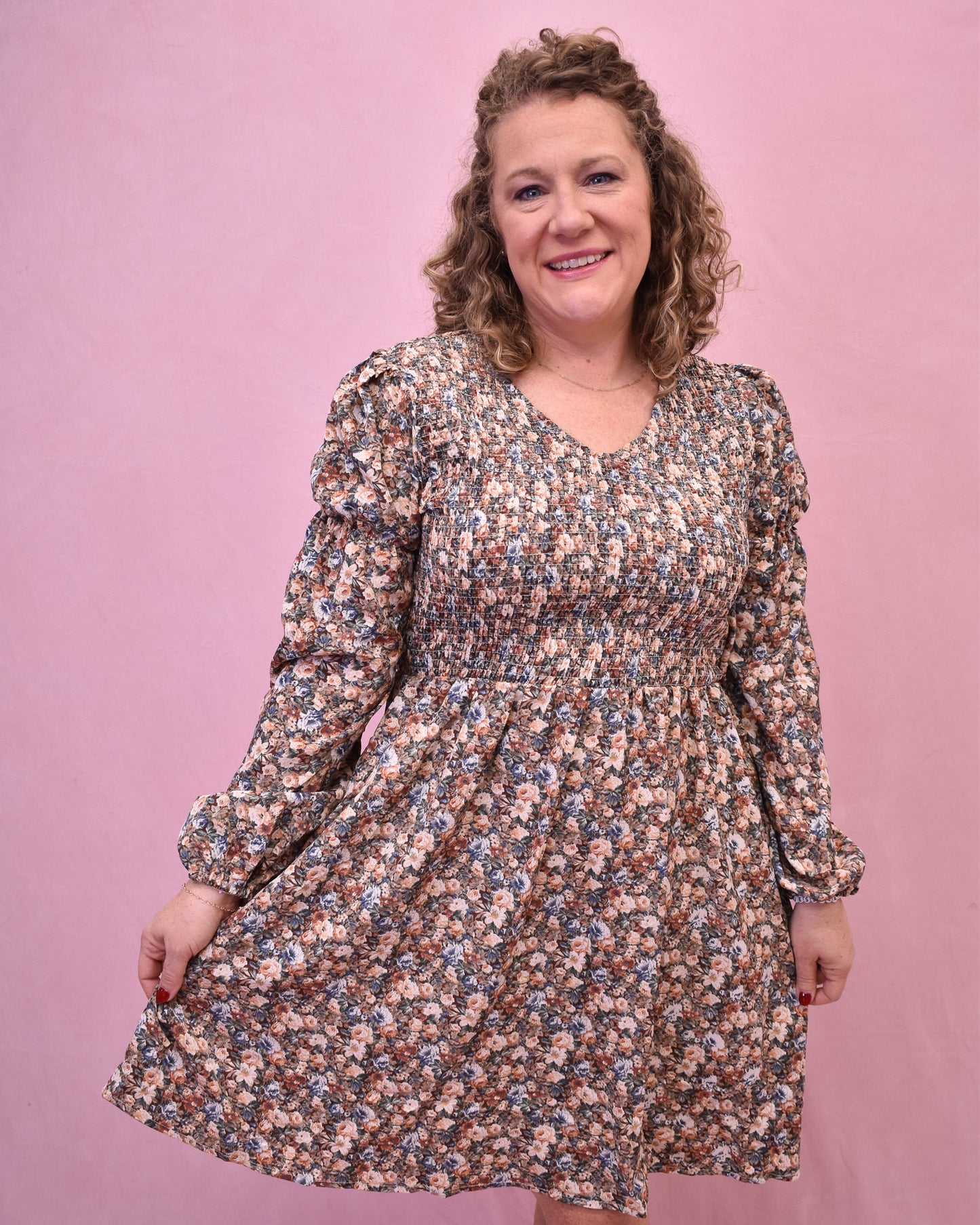 Woman wearing a floral dress against a pink background