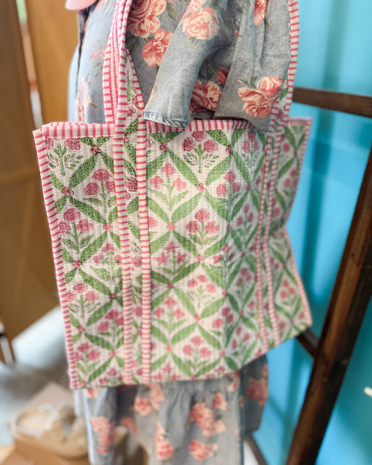 Fabric with floral pattern hanging on a rack against a blue wall