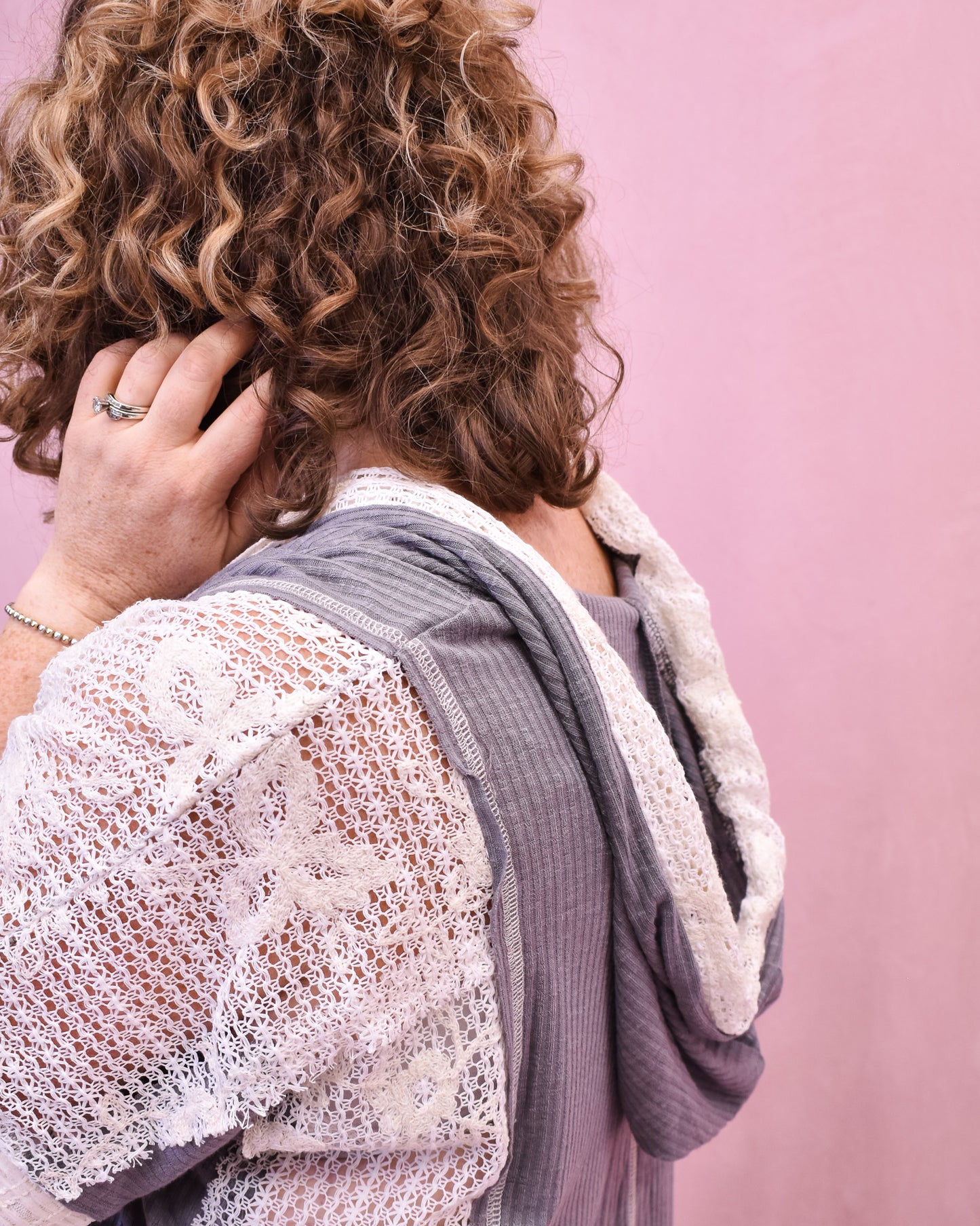 Person wearing a textured garment against a pink background