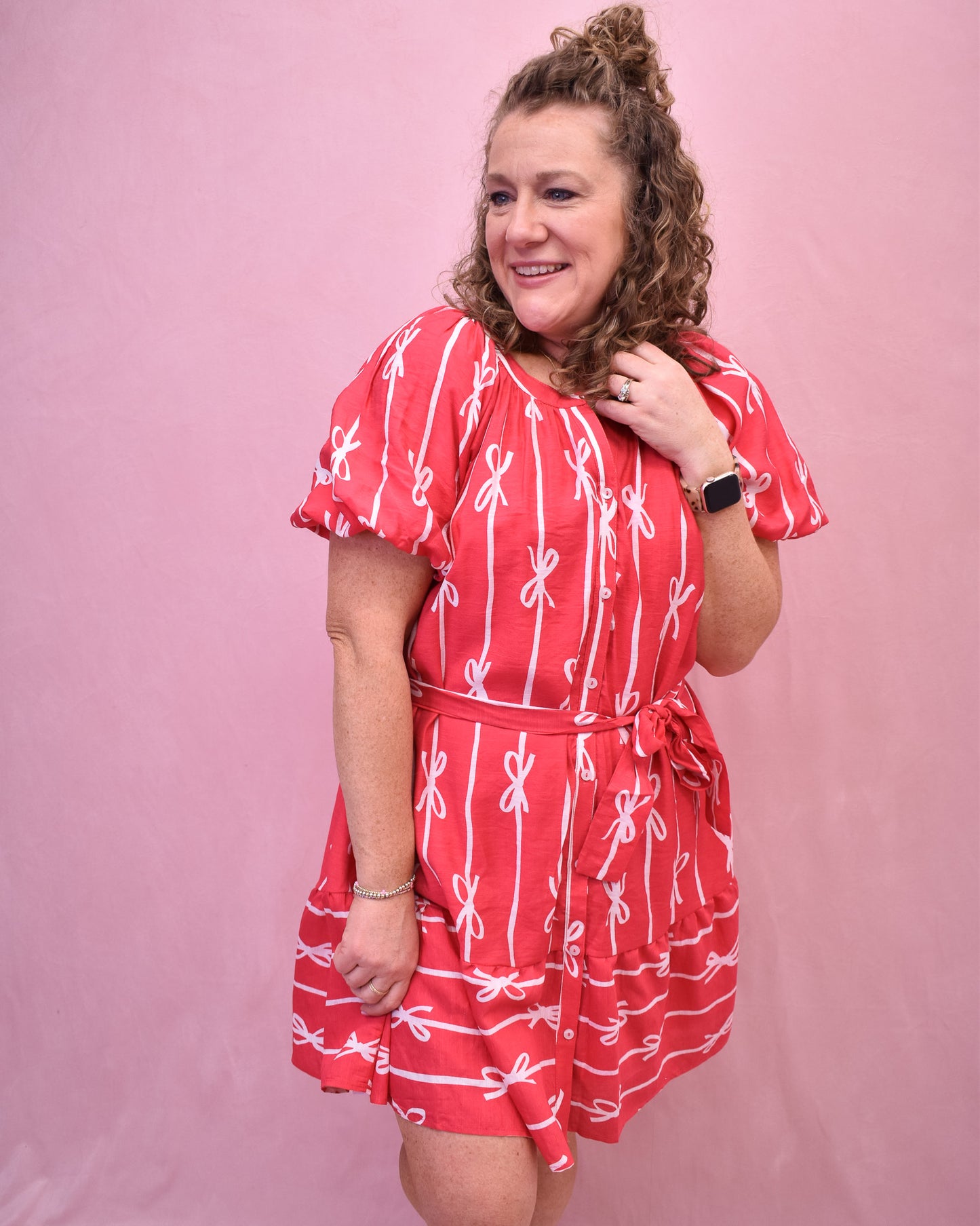 Puff sleeve hot pink dress with buttons down the front and a tie at the waist and bow detail design.