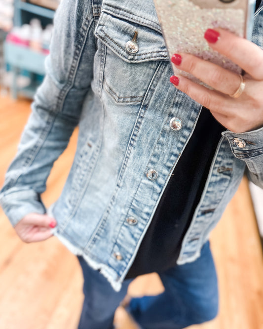 Person wearing a denim jacket with a blurred background