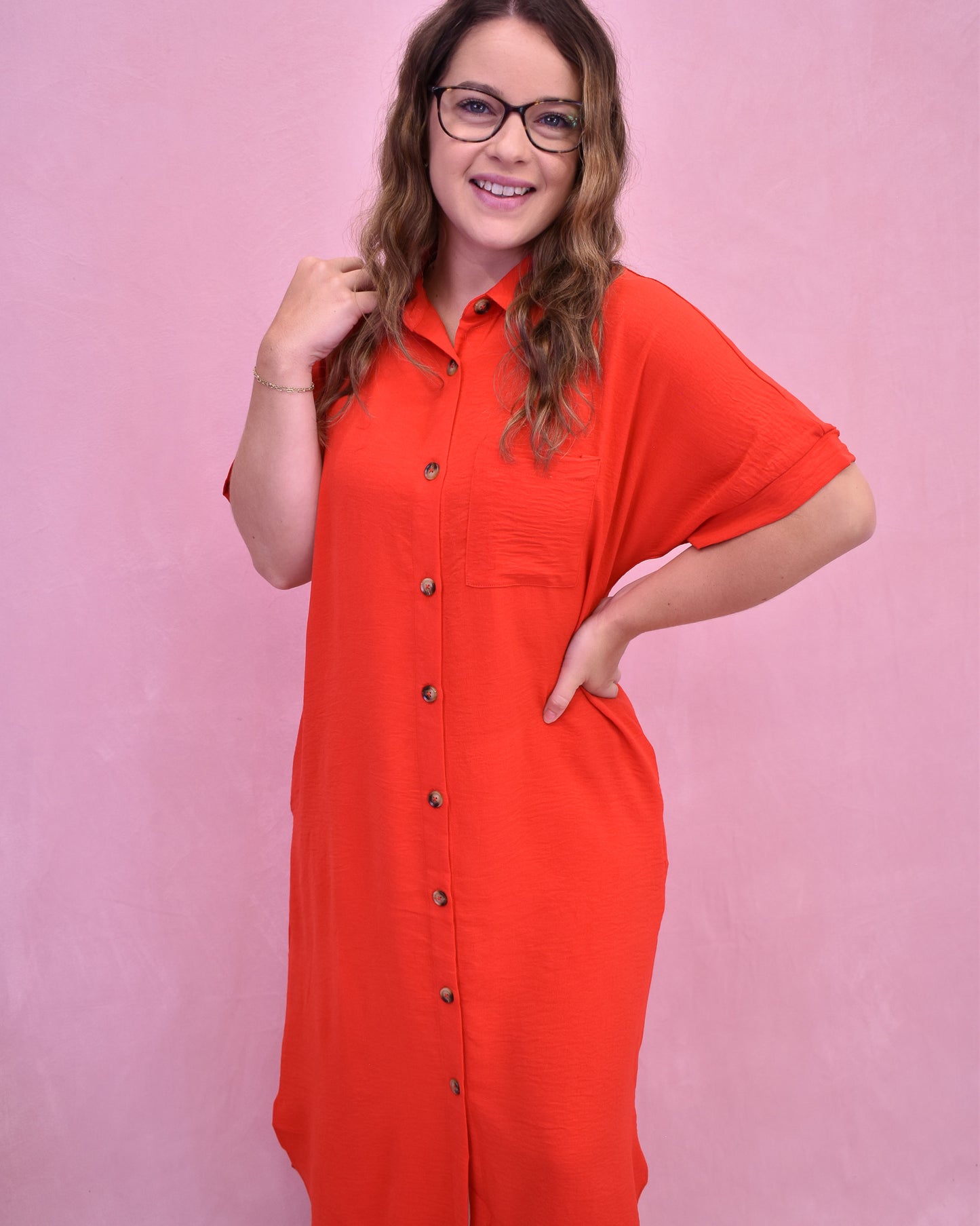 Woman wearing a red dress with a pink background
