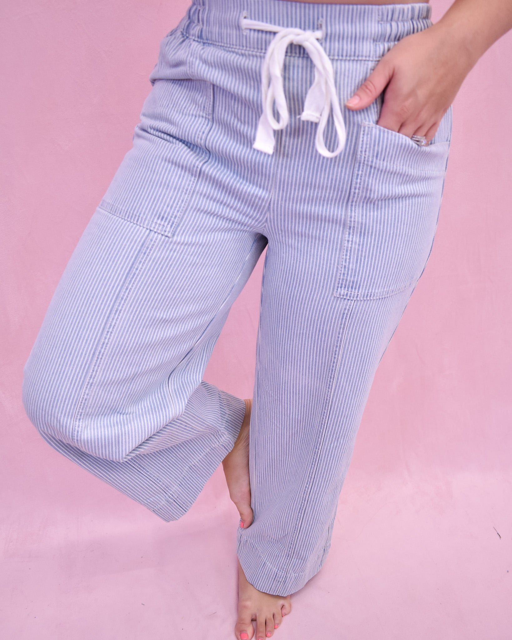 Light blue striped pants with a drawstring on a pink background