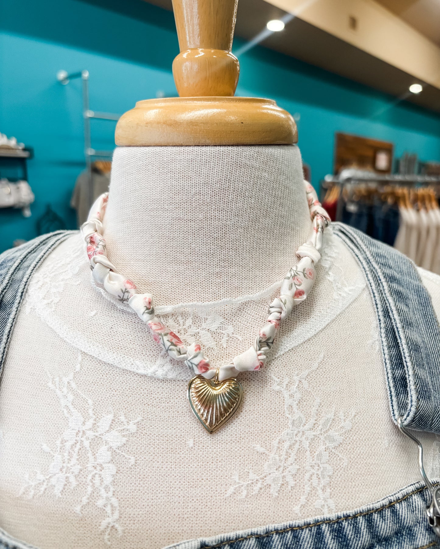 Necklace with a heart-shaped pendant on a mannequin bust in a store setting