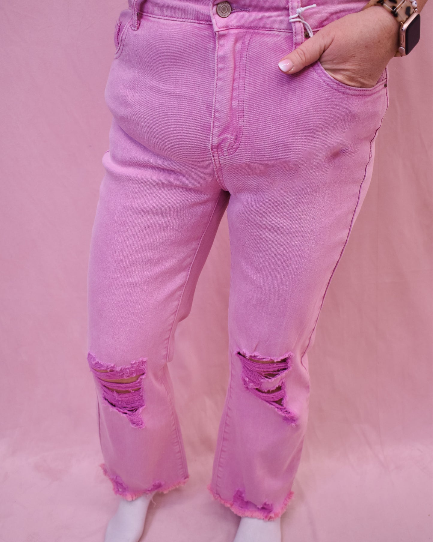 light pink jeans with distressing at the knee and at the hem