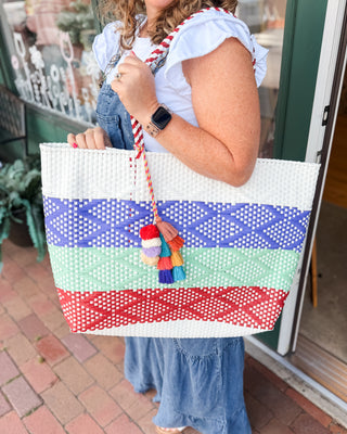 an xlarge sized summer tote multi color with pompom tassel details