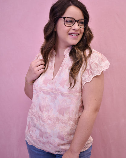 a light pink and cream floral lace top with flutter sleeves