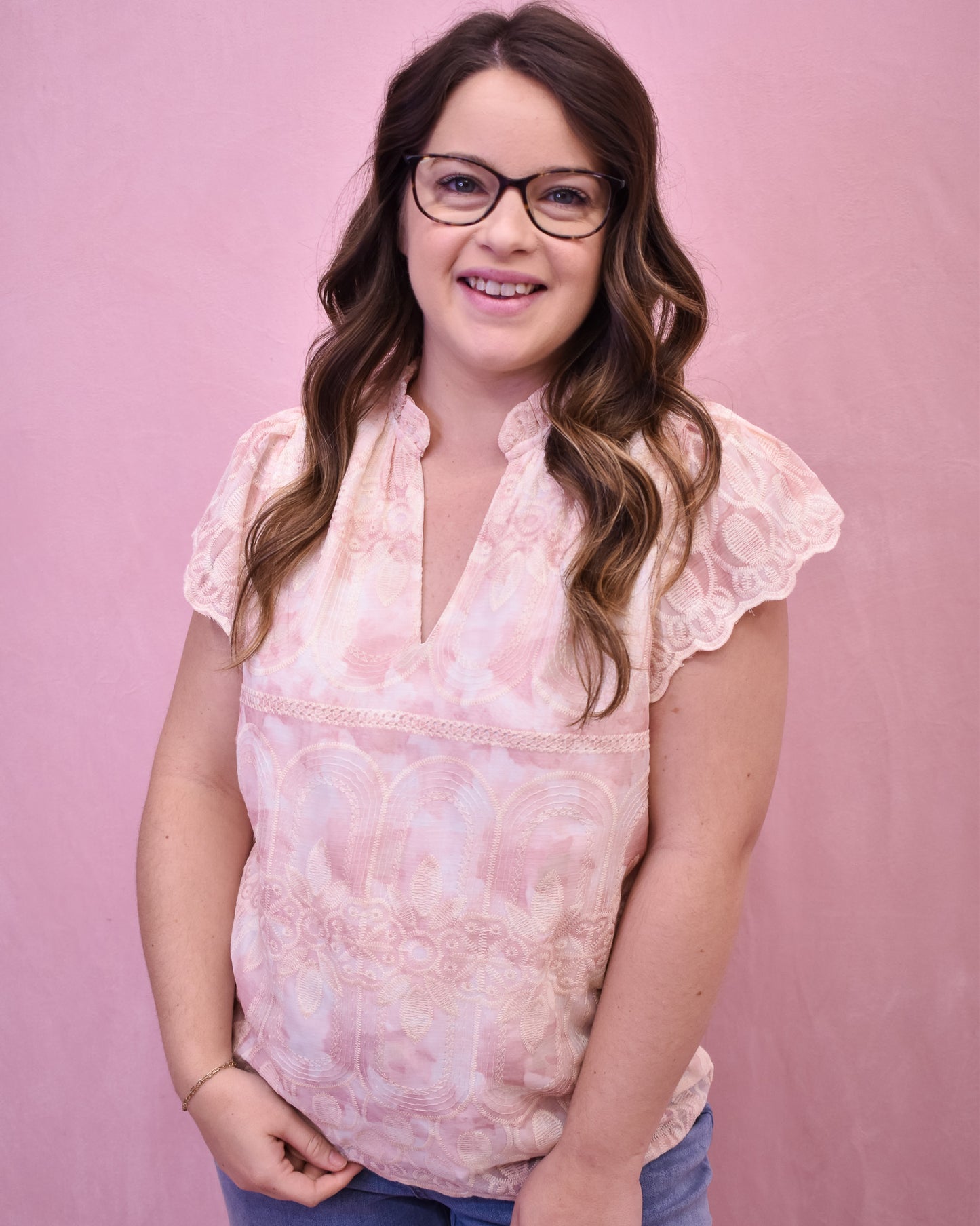 a light pink and cream floral lace top with flutter sleeves
