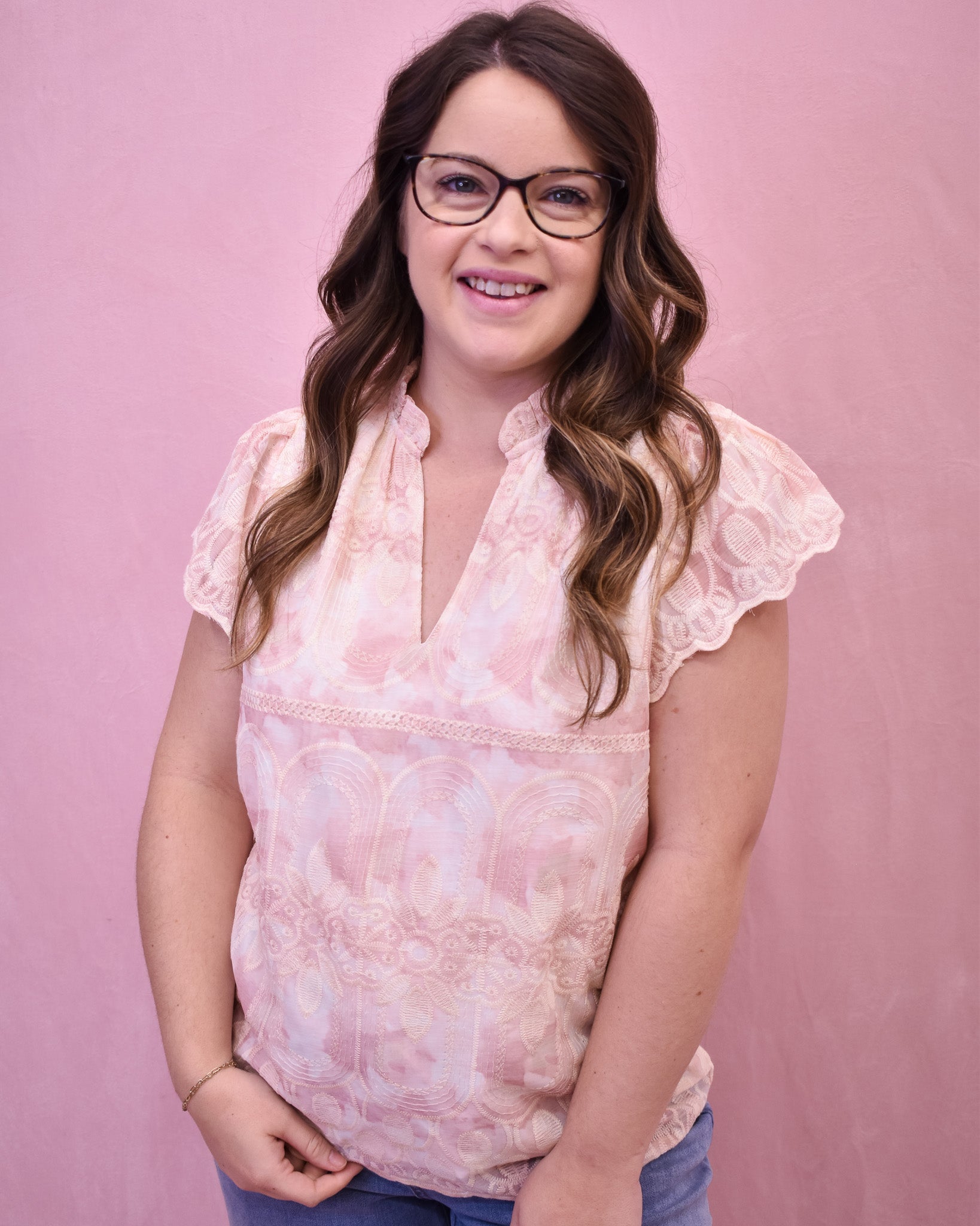 a light pink and cream floral lace top with flutter sleeves