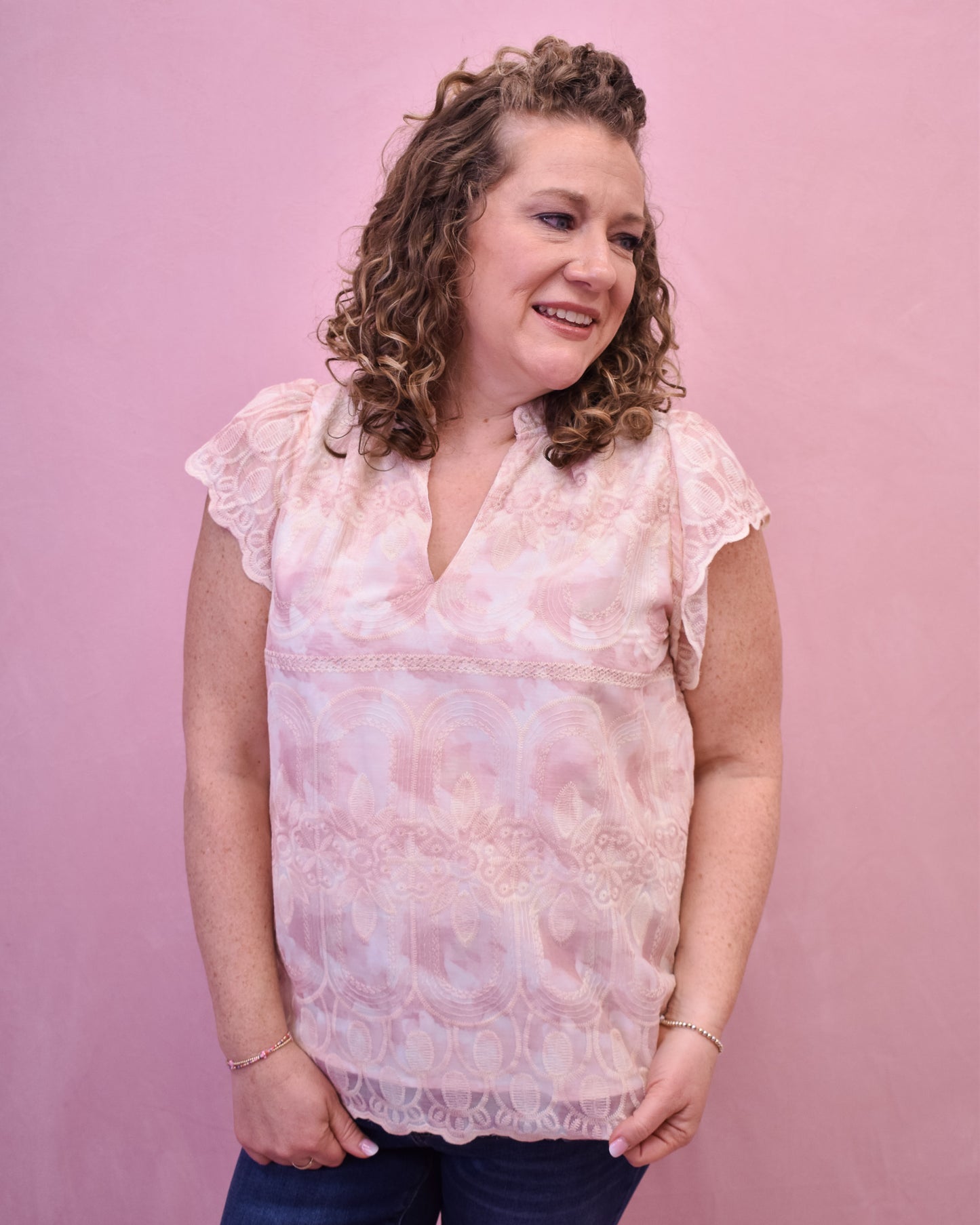 a light pink and cream floral lace top with flutter sleeves