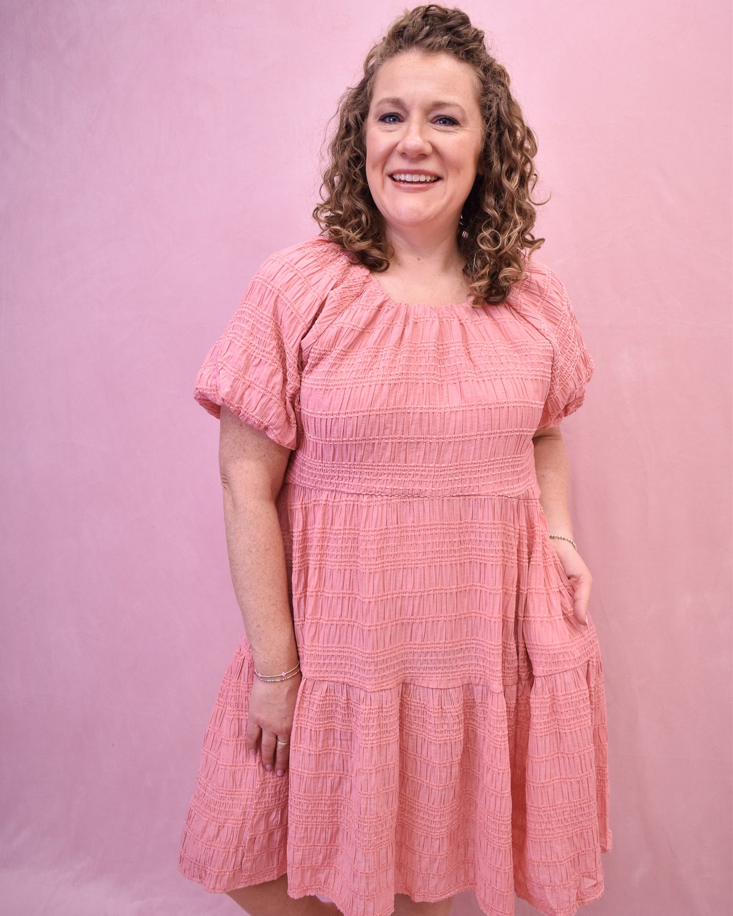 a textured knee length dress in a spring coral color