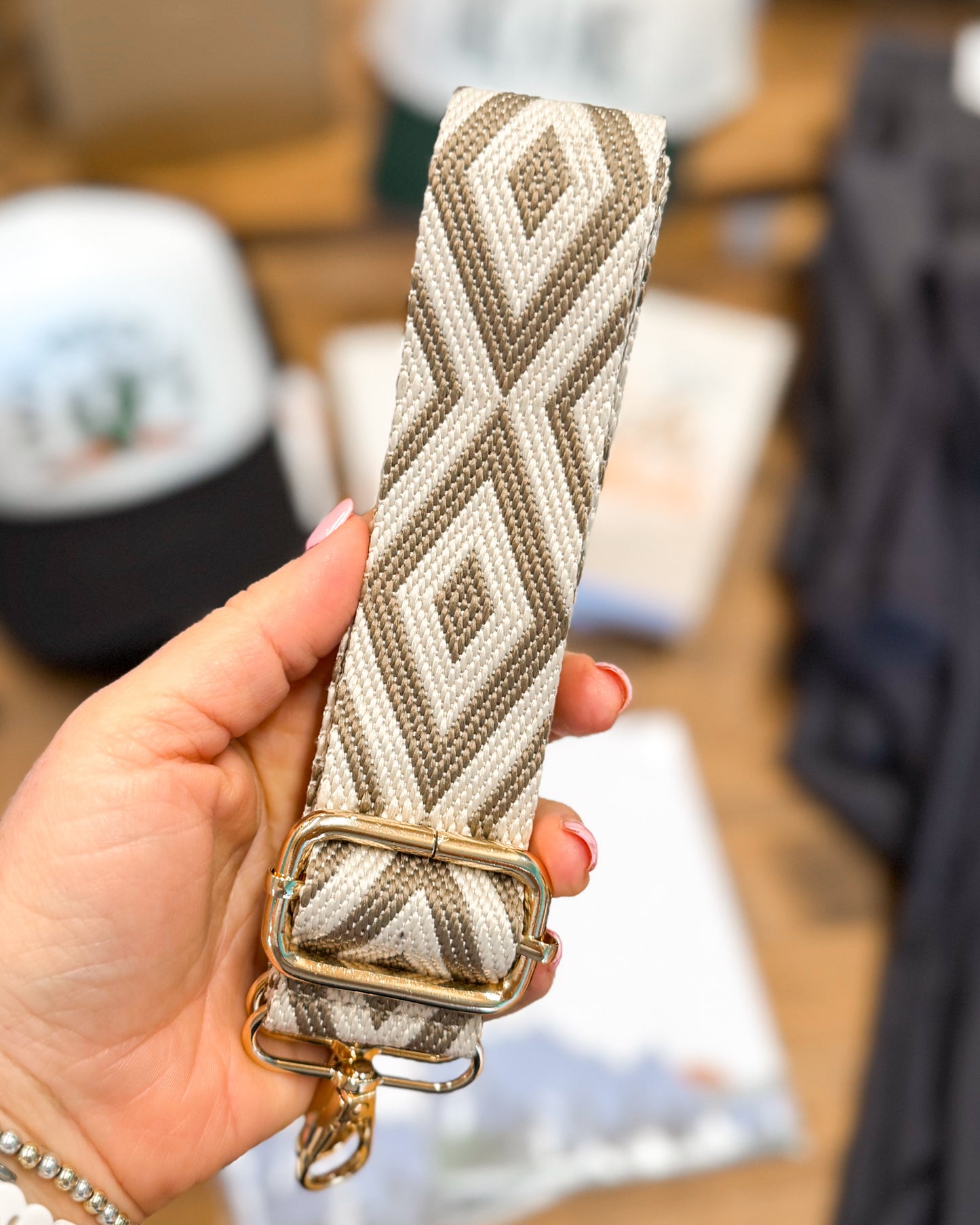 Hand holding a patterned belt with a blurred background