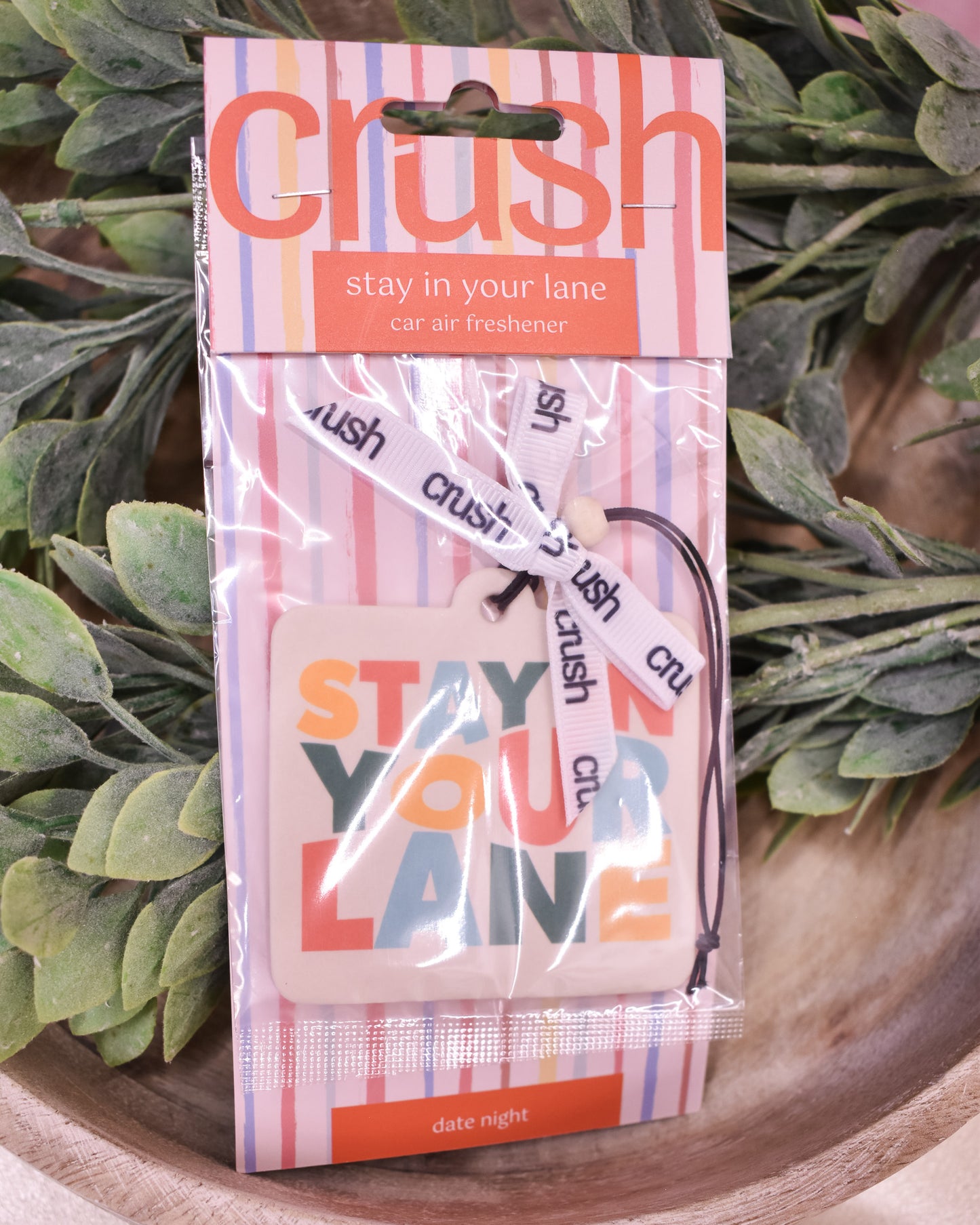 Car air freshener packaging with 'Stay in Your Lane' text on a plant background