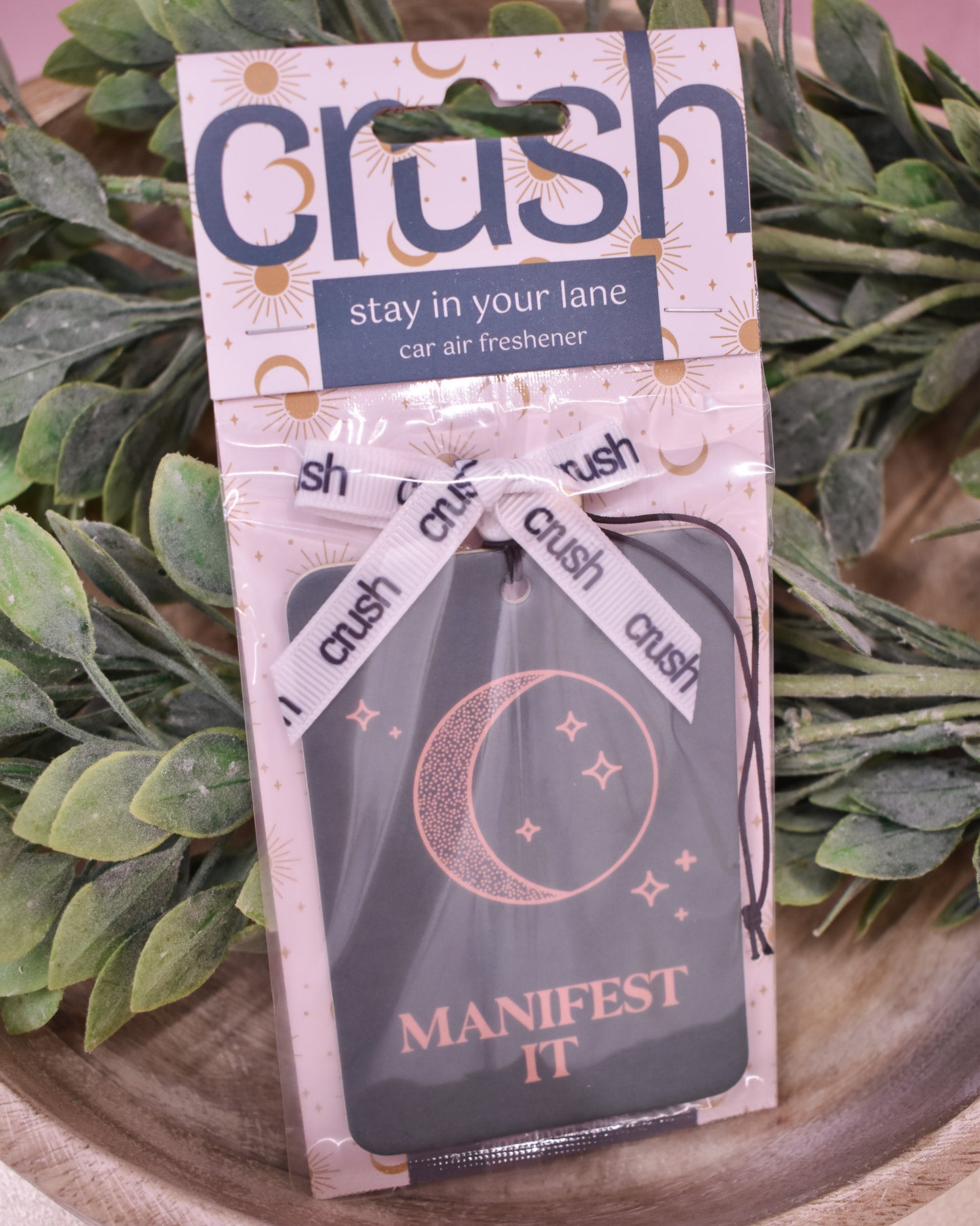 Car air freshener packaging with 'crush' branding and text on a green leafy background