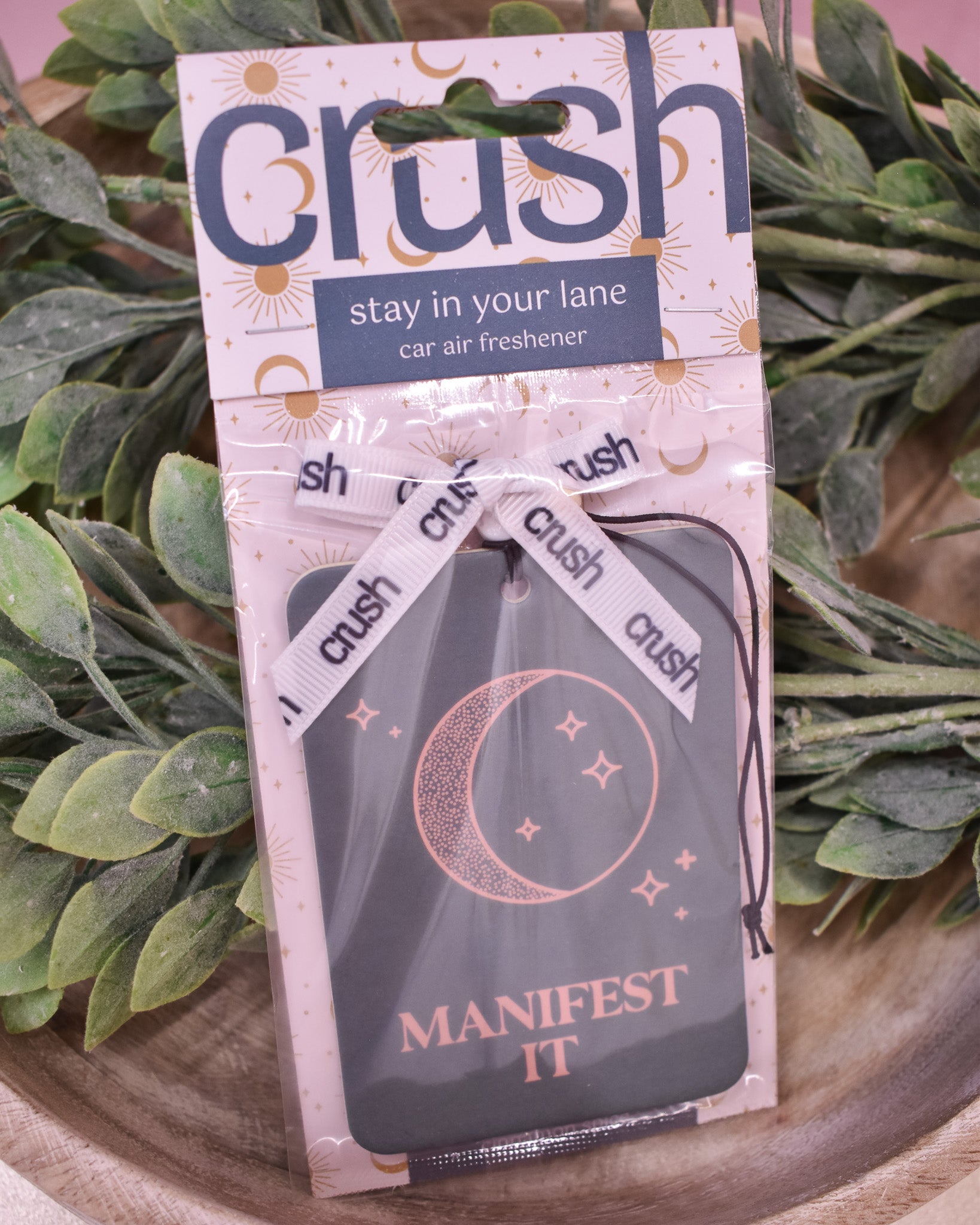 Car air freshener packaging with 'crush' branding and text on a green leafy background