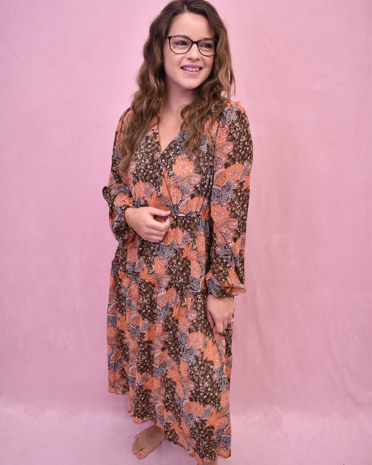 Woman wearing a floral dress against a pink background