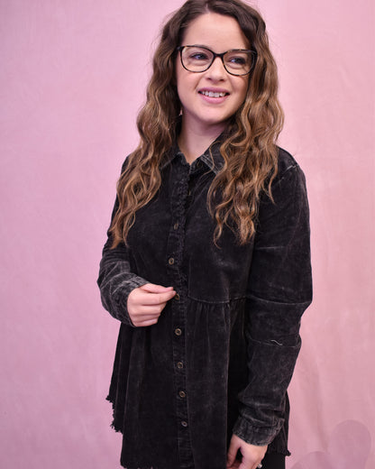 Person wearing a black shirt against a pink background