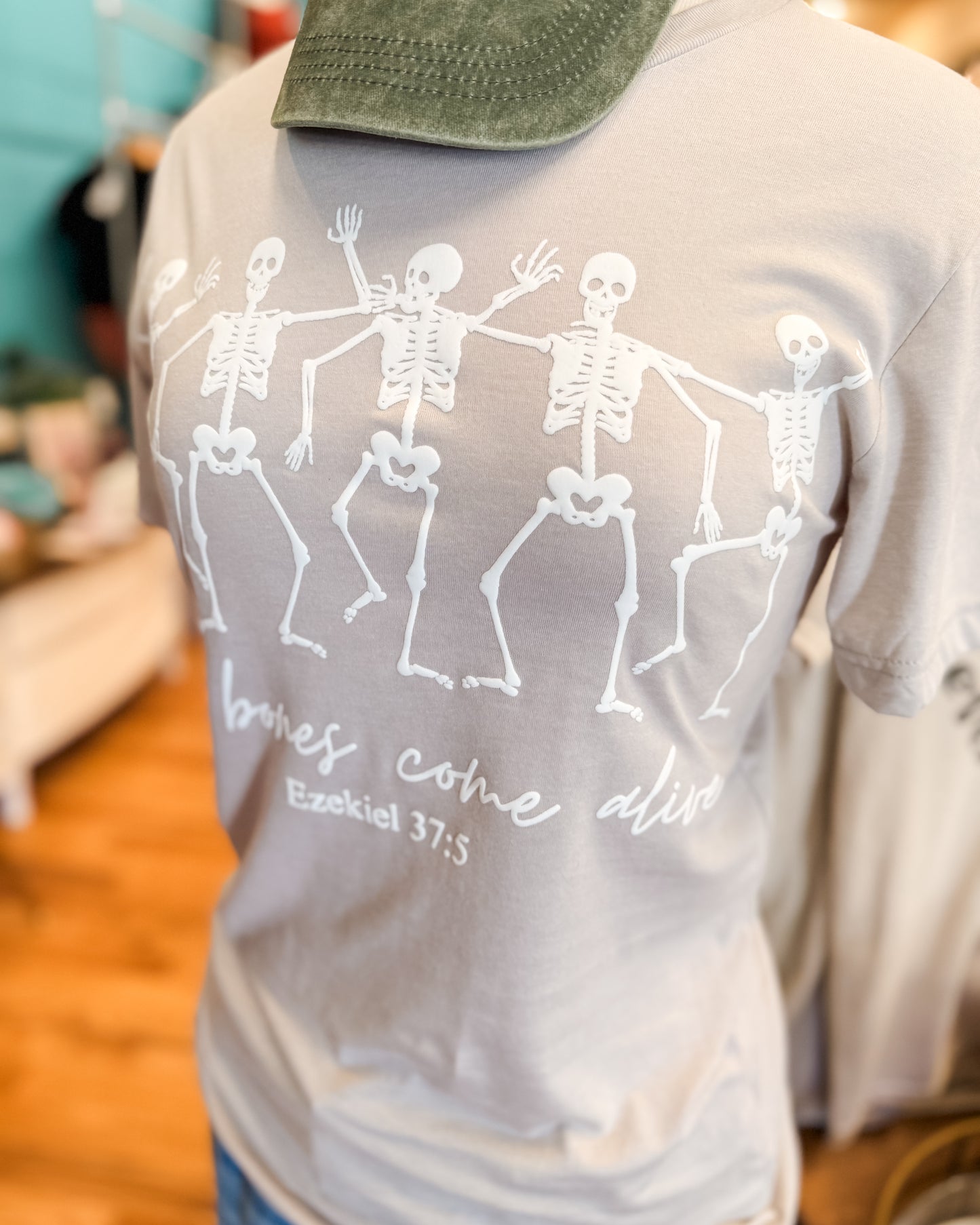Gray t-shirt with skeleton design and text on a blurred background
