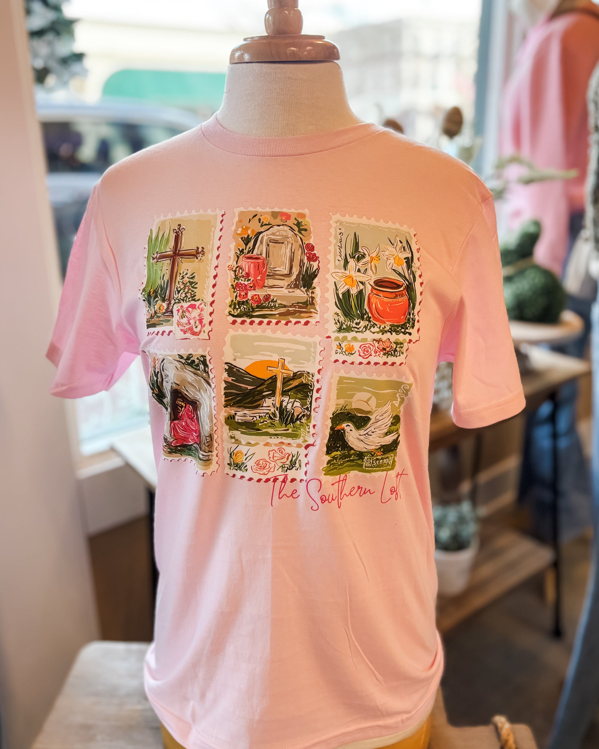 light pink graphic tshirt with stamps projecting the easter story