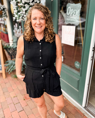 A sleeveless short romper with button down and waist tie