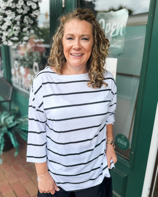 Soft striped slub knit top featuring a flattering boat neckline, longer tunic-length fit, and side slit hem. The perfect casual everyday top to pair with jeans, shorts, or leggings.