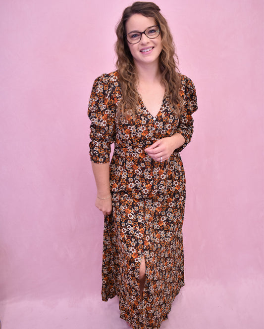 Woman wearing a floral dress against a pink background