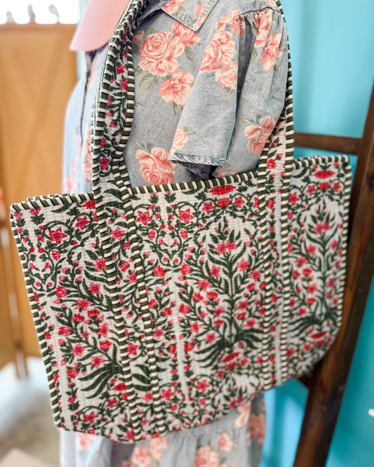 Floral patterned tote bag held by a person with a blurred background