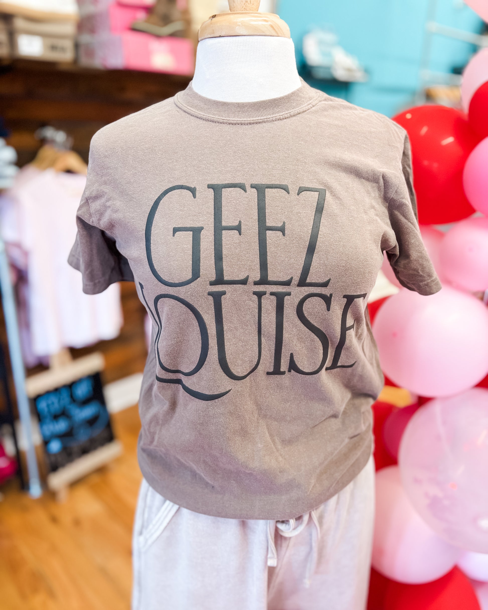 brown graphic tee with the words geez louise on the front