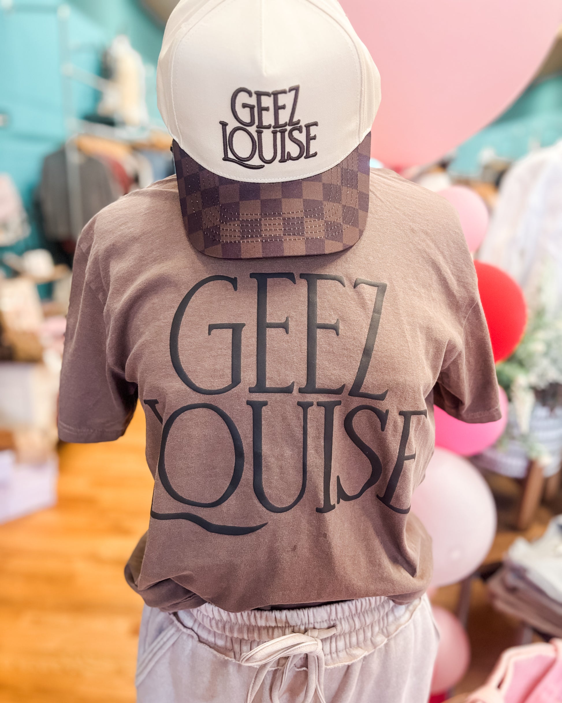 brown graphic tee with geez louise in puff ink on the front, canvas hat with brown checkered bill with geez louise embroidered.