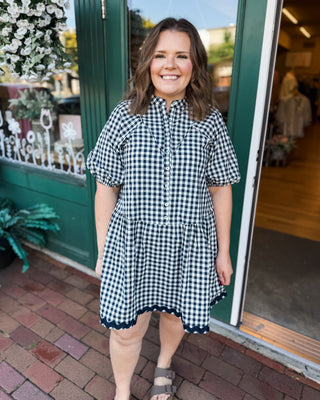 a short sleeve drop hem navy gingham dress with button down front and ric rac hem details
