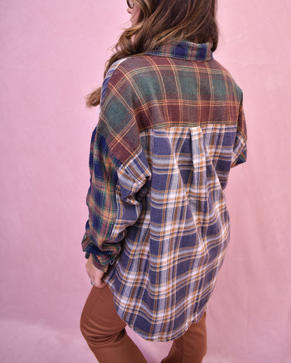 Person wearing a plaid shirt with a pink background