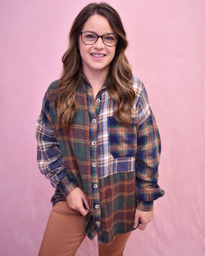 Woman wearing a plaid shirt and glasses against a pink background