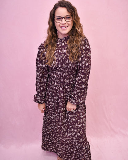 Woman wearing a floral dress against a pink background