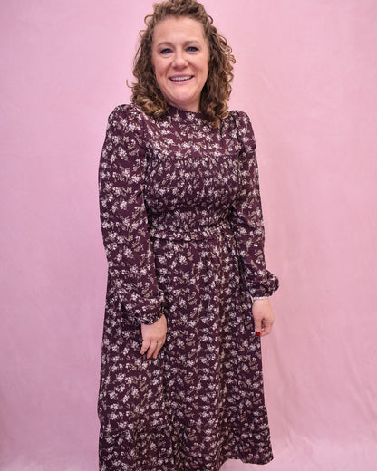 Woman wearing a floral dress against a pink background