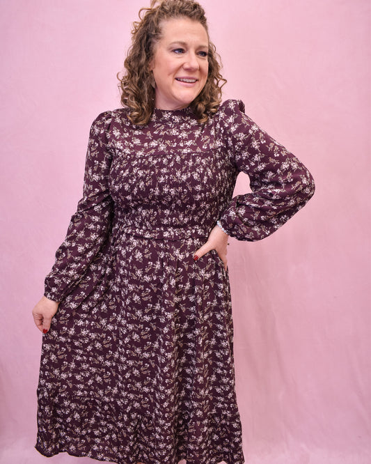 Woman wearing a floral dress against a pink background