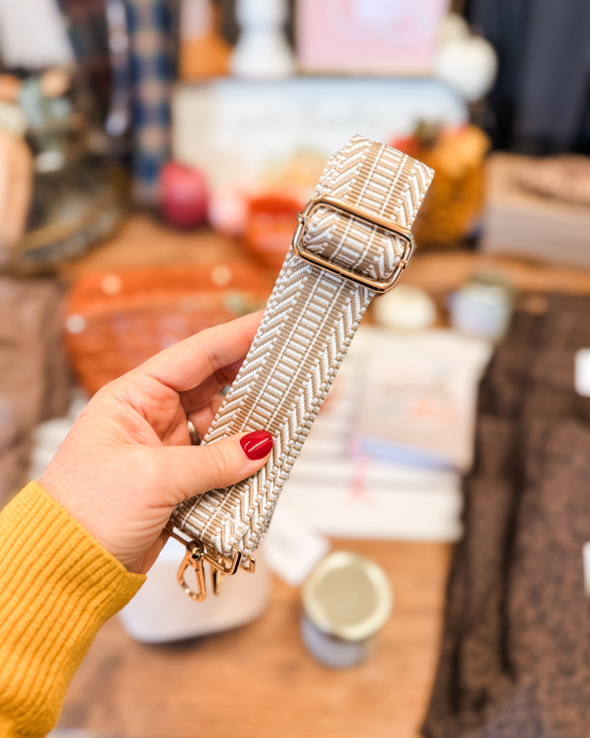 Hand holding a textured belt with a blurred store background