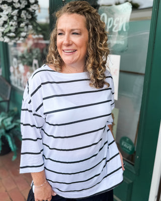 Soft striped slub knit top featuring a flattering boat neckline, longer tunic-length fit, and side slit hem. The perfect casual everyday top to pair with jeans, shorts, or leggings.