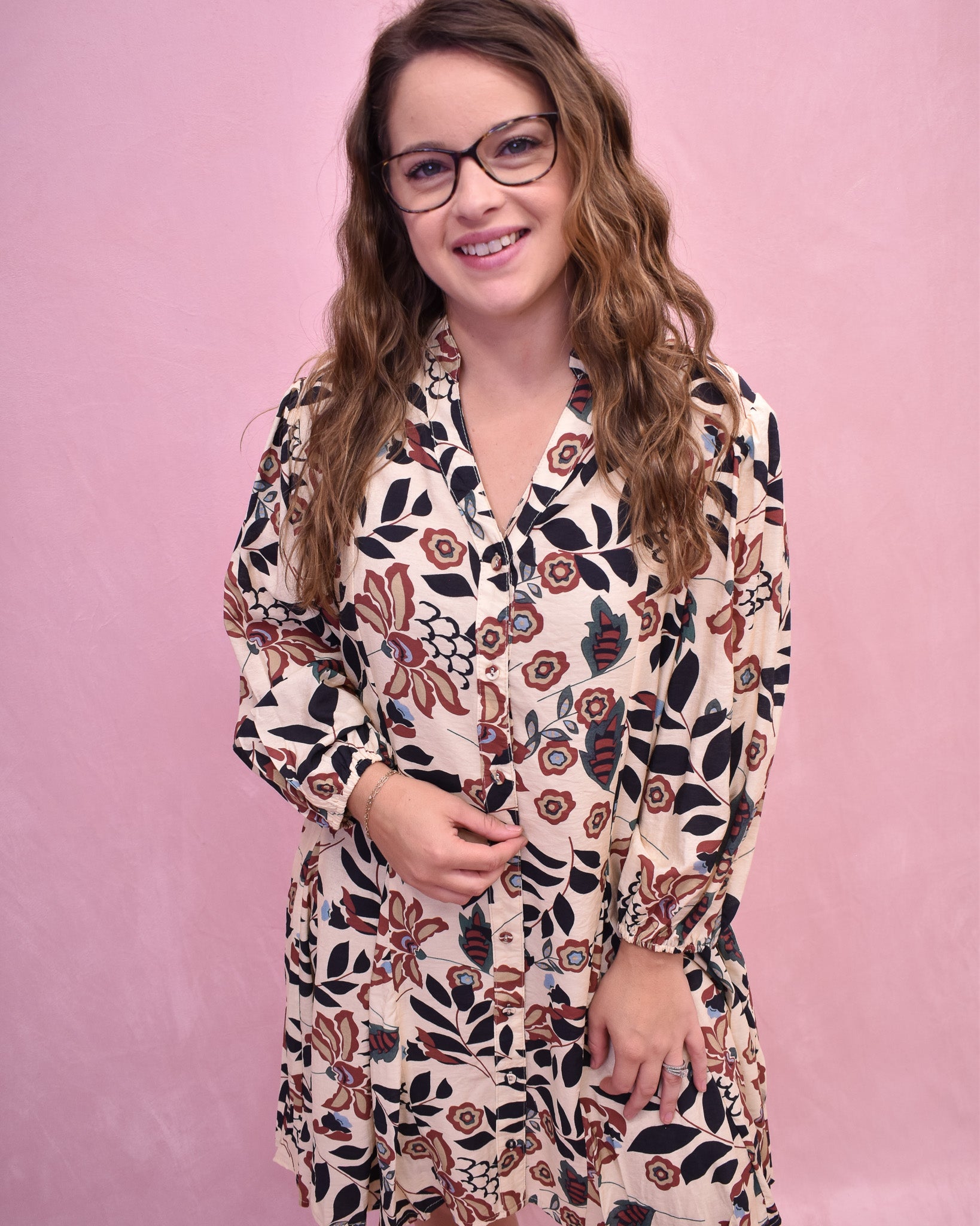 Woman wearing a floral dress against a pink background